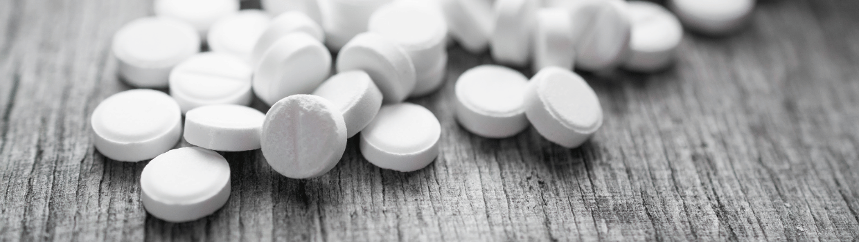 White chipped tablets on a wooden surface.