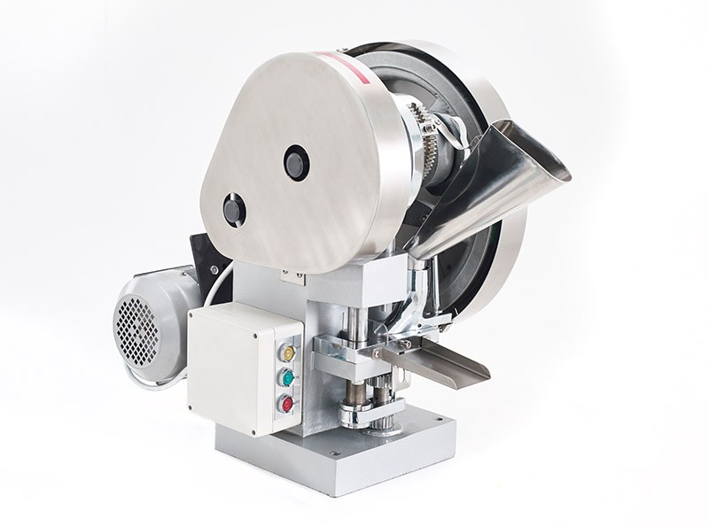 What is a single station tablet press and how does it work?