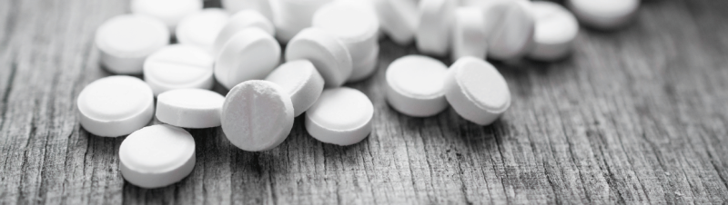 White chipped tablets on a wooden surface.